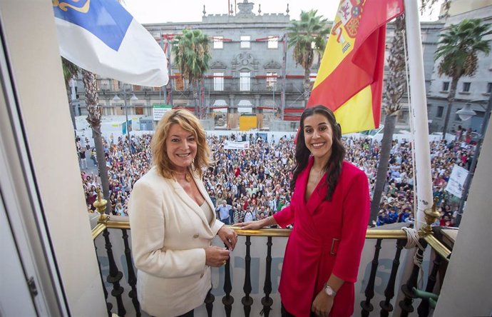 La alcaldesa de Huelva, Pilar Miranda (i) y la deportista Carolina Marín (d) posan en el balcón del Ayuntamiento con miles de onubenses a sus pies.