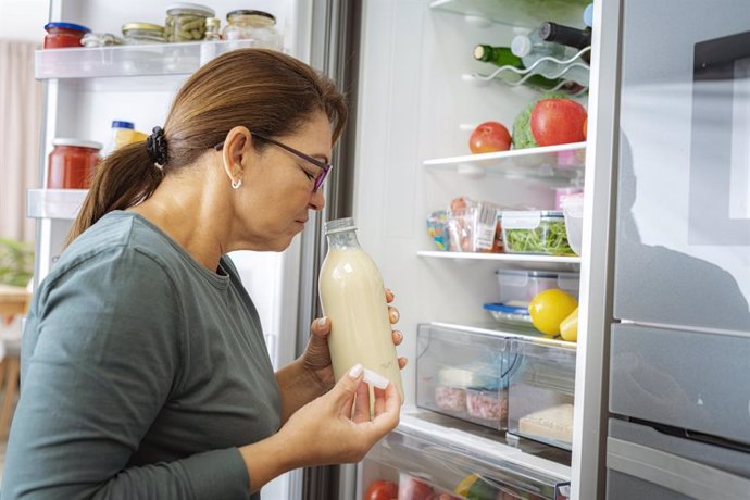 Archivo - Mujer Disgustada Que Huele Leche Junto A La Nevera