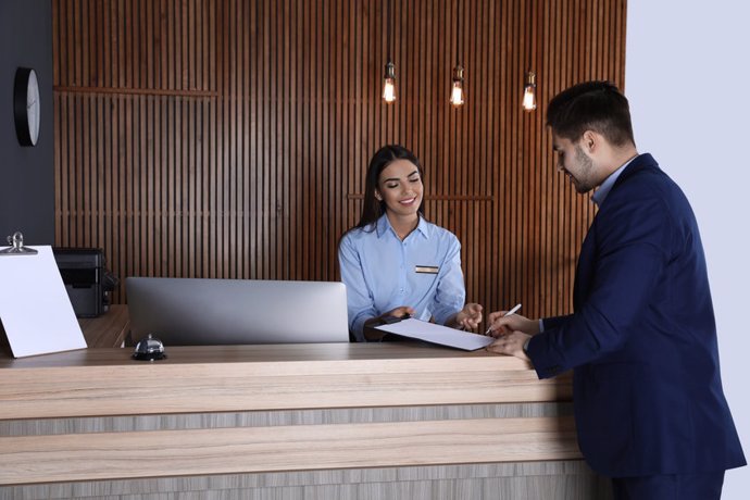 Archivo - Un turista se registra a la entrada en un hotel