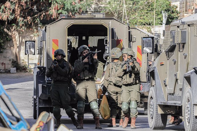 September 11, 2024, Tubas, West Bank, Palestine: Israeli soldiers stand guard as other soldiers arrest a Palestinian after raiding his home during the raid on the city of Tubas. A large-scale Israeli military raid on the city of Tubas in the northern occu