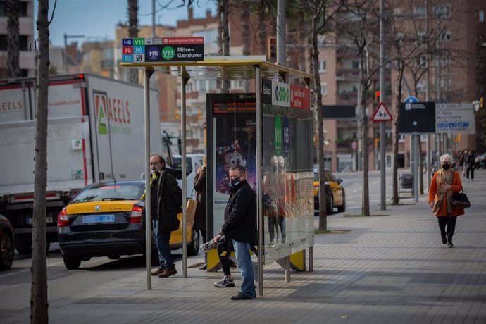 Archivo - Taxis pasan junto a una parada, donde varias personas esperan el autobús, durante la huelga de autobuses en Mitre Ganduxer, a 17 de febrero de 2022, en Barcelona, Cataluña, (España).