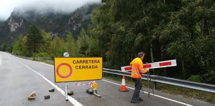 Un operario de la Dirección General de Carreteras e Infraestructuras retira la valla que cortaba la A-138.