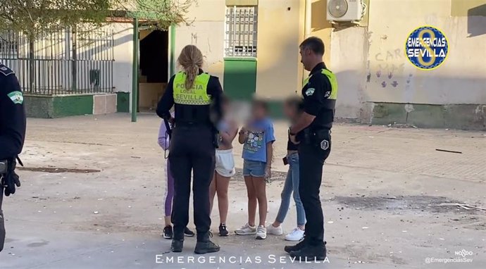 Dos policías locales junto a varios menores, en foto de archivo.