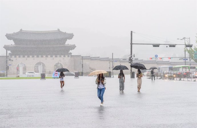 Archivo - July 18, 2024, Seoul, South Korea: People holding umbrellas to protect themselves from rain walk through central Gwanghwamun square in Seoul. Torrential downpours pelted the broader Seoul area and adjacent regions on July 18, leading to the evac