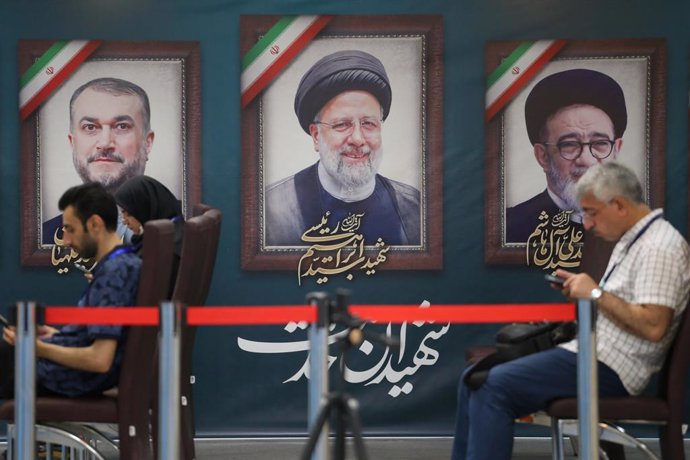 Archivo - May 31, 2024, Tehran, Iran: Iranian photojournalists sit next to a portrait of Iranian late President Ebrahim Raisi and late Iranian Foreign Minister Hossein Amirabdollahian, in the candidates' registration office at the Interior Ministry in Teh