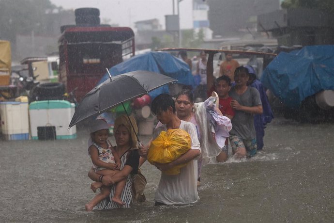 Archivo - July 24, 2024, Quezon City, Metro Manila, Philippines: Residents wade through flood waters following heavy monsoon rains in Manila, Philippines. July 24, 2024. The Philippine government has placed the capital of Manila under state of calamity af