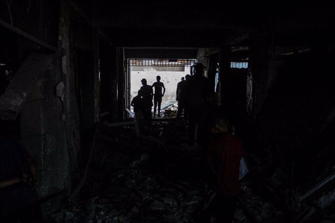 Imagen de archivo de palestinos buscando bajo los escombros en una escuela tras un ataque israelí