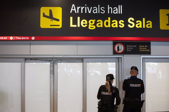 Archivo - Dos agentes de la Policía Nacional en la puerta de llegadas de la terminal T1 del Aeropuerto Adolfo Suárez Madrid Barajas, por la previsible llegada del expresidente de la Real Federación Española de Fútbol (RFEF), a 3 de abril de 2024, en Madri