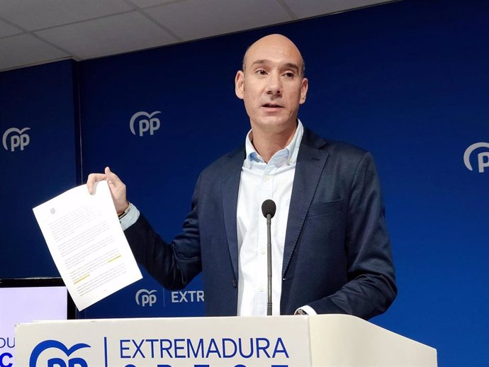 El portavoz del PP de Extremadura, José Angel Sánchez Juliá, muestra el documento que refleja la fecha de finalización del trazado del AVE extremeño.