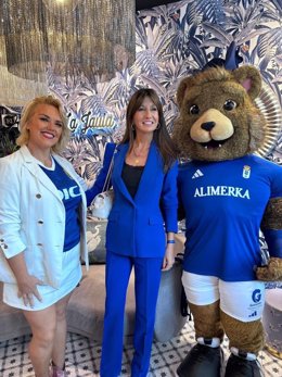 La concejala de Economía, Leticia González, con la mascota del Real Oviedo y la propietaria de un comercio local.