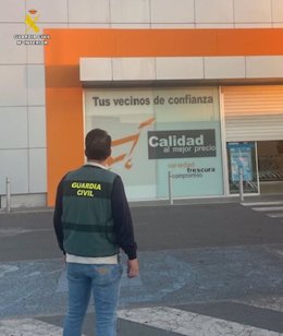 Un guardia civil frente al supermercado en el que se produjo el robo en Íscar.