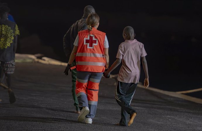 Un trabajador de la Cruz Roja atiende a uno de los migrantes que ha llegado al Puerto de La Restinga tras ser rescatados por la Guardamar Calliope