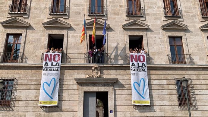 La delegada de Gobierno en la Comunitat Valenciana, Pilar Bernabé, despliega una pancarta en contra de la explotación sexual y la trata