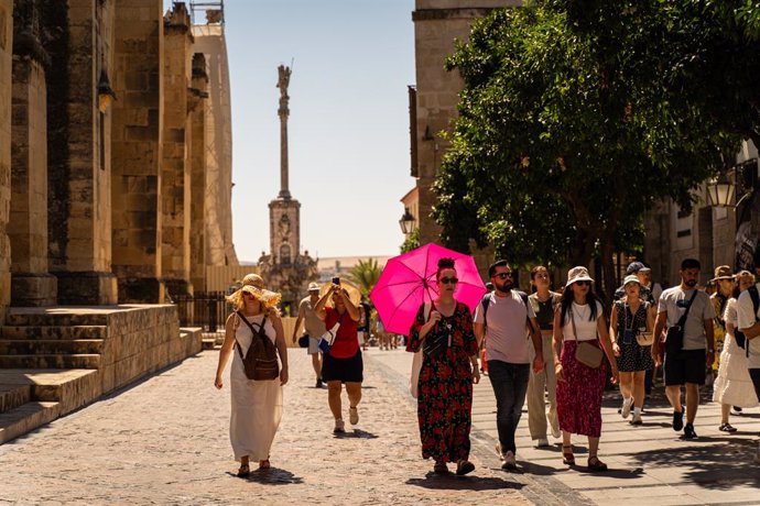 Archivo - Turistas y cordobeses se resguardan del sol para hacer frente a las altas temperaturas.