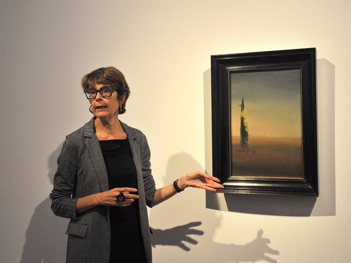 La directora dels Museus Dalí, Montse Aguer, junt amb l'oli surrealista 'El naixement dels angoixes líquides' en el Teatre-Museu Dalí