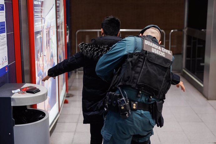 Archivo - Un agente de la Guardia Civil cachea a un joven en un control para prevenir la violencia entre bandas juveniles en Madrid