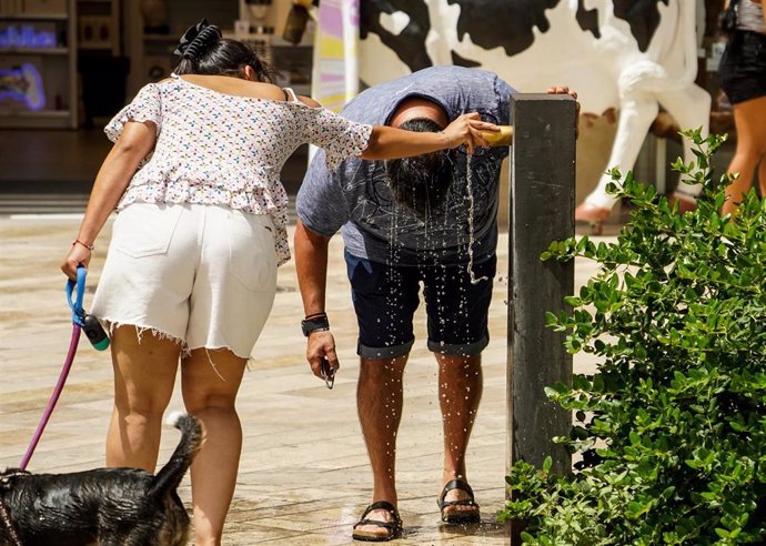 Archivo - Un hombre se refresca en una fuente en València en imagen de archivo.