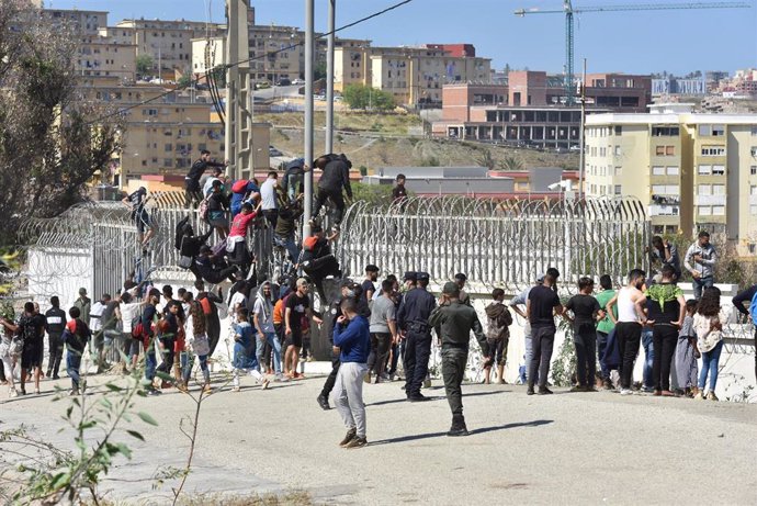 Archivo - Migrantes marroquíes tratando de saltar la verja fronteriza con Ceuta