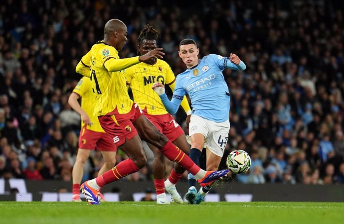 24 September 2024, United Kingdom, Manchester: Manchester City's Phil Foden (R) and Watford's Angelo Ogbonna battle for the ball during the English Carabao Cup third round soccer match between Manchester City and Watford at the Etihad Stadium. Photo: Mart