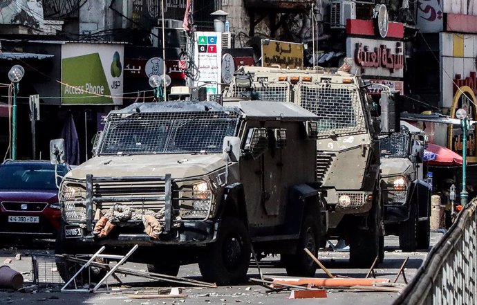 September 22, 2024, Nablus, West Bank, Palestine: Pieces of iron and stones are seen in front of military vehicles placed by Palestinian youths to obstruct the progress of the vehicles while besieging a building in the middle of the market during a milita