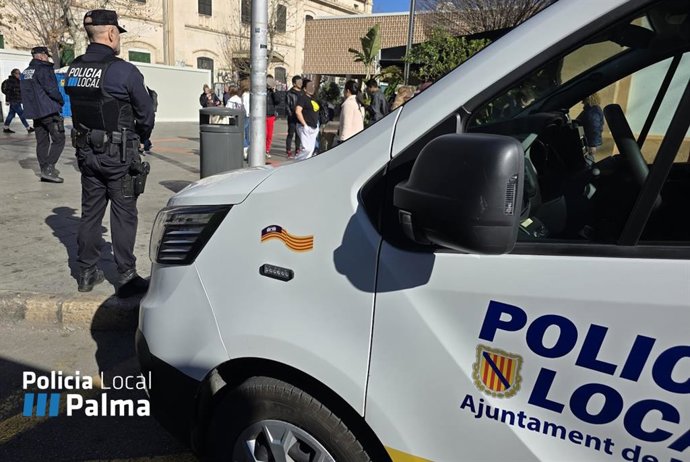 Un agente de la Policía Local de Palma, junto a un vehículo.