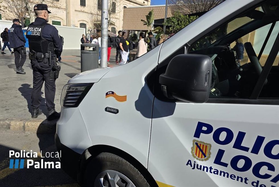 Un agente de la Policía Local de Palma, junto a un vehículo.