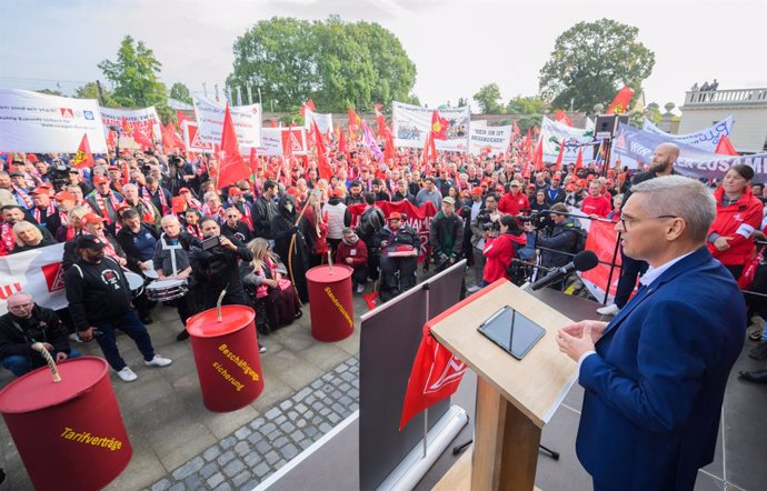 25 September 2024, Lower Saxony, Hanover: Thorsten Groeger (rR), lead negotiator for IG Metall, speaks in front of Herrenhausen Palace before the start of collective bargaining between Volkswagen and IG Metall. Photo: Julian Stratenschulte/dpa