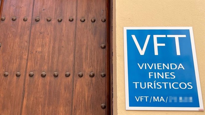 Imagen de recurso de la puerta de una vivienda turística con el cartel indicativo de licencia de 'Vivienda con Fines Turísticos'.