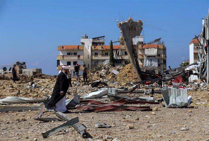 Un clérigo suní libanés inspecciona los daños causados por un ataque aéreo israelí en los alrededores de la ciudad de Jiyé