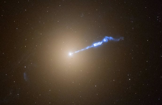 Imagen del Hubble de la galaxia gigante M87 con un chorro de plasma de 3.000 años luz que sale disparado del agujero negro central de la galaxia. El chorro, que parece un soplete, parece provocar la erupción de estrellas en su trayectoria