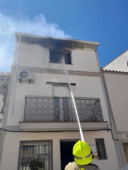 Un bombero apaga un incendio en una vivienda de Casar de Cáceres en una foto de archivo