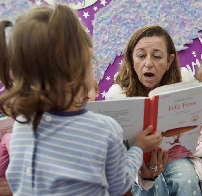 La consejera de Educación lee un cuento a una alumna del colegio Virgen de Luna de Villanueva de Córdoba.