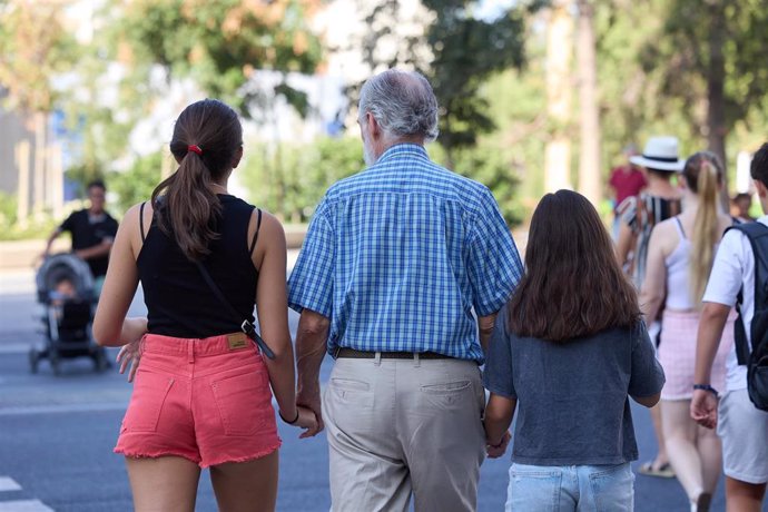 Un señor mayor camina por una calle 