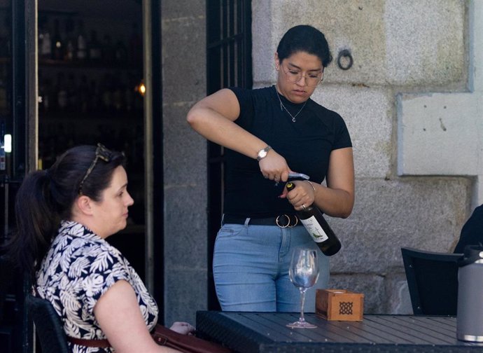 Archivo - Una camarera sirve una copa de vino.