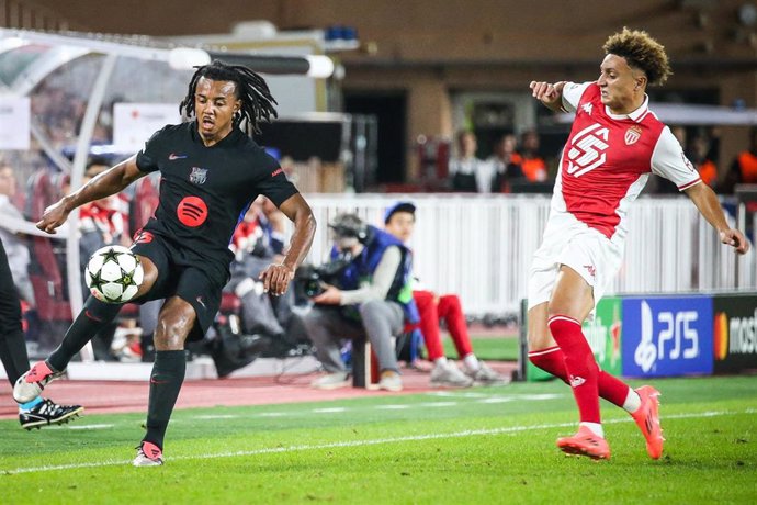 Barcelona's Jules Kounde (L) and Monaco's Eliesse Ben Seghir battle for the ball during the UEFA Champions League soccer match between AS Monaco and FC Barcelona at Louis II Stadium