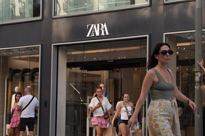 Varias personas pasan delante de una tienda Zara 