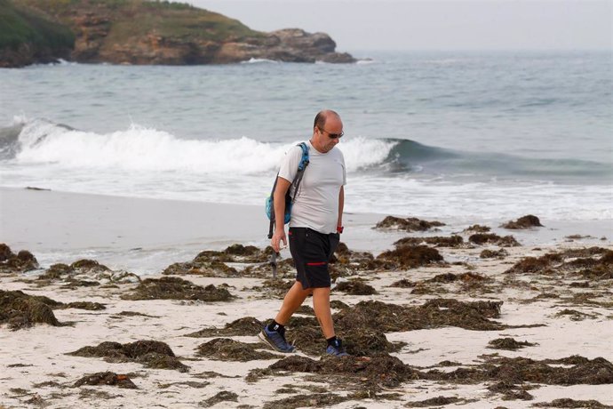 Un hombre pasea durante la pleamar en la playa de A Rapadoira, a 19 de septiembre de 2024, en Lugo, Galicia (España). 