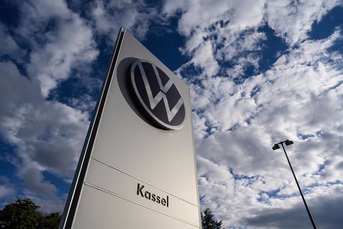 PRODUCTION - 12 September 2024, Hesse, Baunatal: View of a stele with the Volkswagen logo in front of the plant building. 