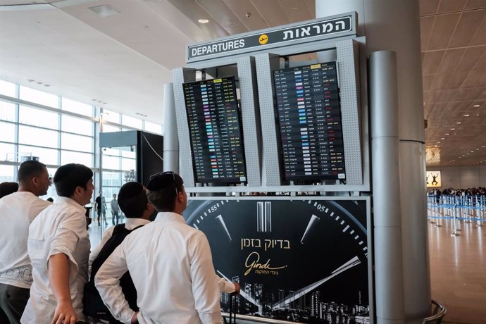 Archivo - August 4, 2024, Lod, Israel: Passengers check their flights on the departures board at Tel Aviv's Ben Gurion International Airport near Lod, showing numerous delays (yellow) and cancellations (red). Despite the peak travel season, the airport se