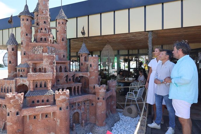 El alcalde de Torrox (Málaga), Óscar Medina, acompañado por el artista Anton Jensen y el CEO del grupo Yobí Yobá, Jorge López, ha inaugurado el castillo Maini en El Peñoncillo, a las puertas del chiringuito Media Caña