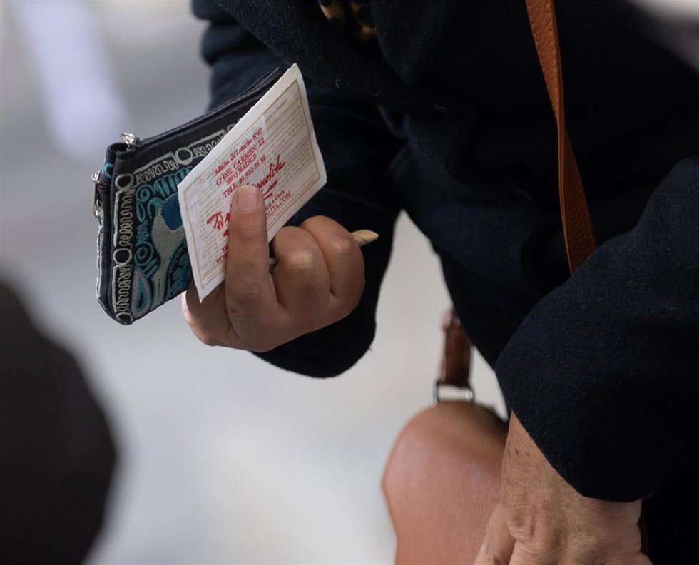 Archivo - Una persona sujeta un décimo de la administración de lotería Doña Manolita de cara al Sorteo Extraordinario de la Lotería de Navidad, en la Administración de Loterías Doña Manolita, a 14 de diciembre de 2023, en Madrid (España). El establecimi