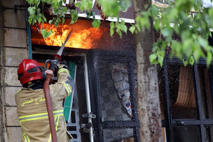 BEIRUT, Sept. 28, 2024  -- A firefighter tries to extinguish a fire after Israeli airstrikes in the southern suburbs of Beirut, Lebanon, Sept. 28, 2024.