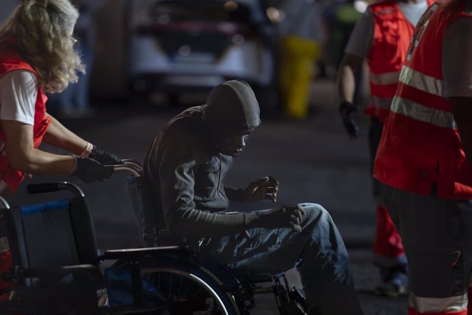 Un trabajador de la Cruz Roja atiende a uno de los migrantes que ha llegado al Puerto de La Restinga tras ser rescatados por la Guardamar Calliope, a 20 de septiembre de 2024, en El Hierro, Canarias (España). La Guardamar Calliope salió a buscar a una emb