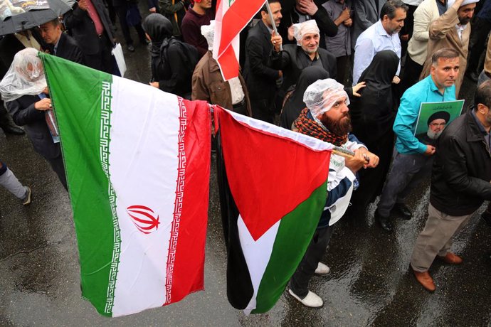 September 28, 2024, Tehran, Iran: An Iranian demonstrator holds an Iran and Palestine flag during an anti-Israel protest at Palestine Square in downtown Tehran. The Lebanese militant group Hezbollah confirmed that its leader, Hassan Nasrallah, was killed 