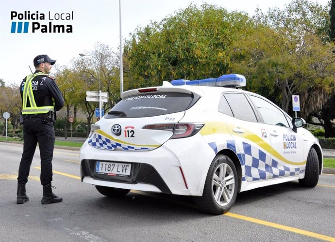 Agente de la Policía Local de Palma, junto a un vehículo policial. Recurso. Archivo.