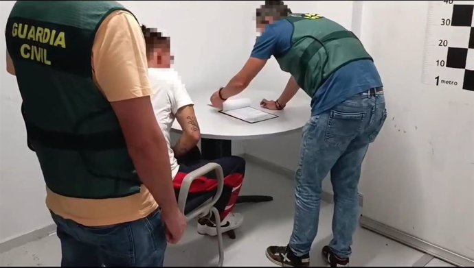 Dos agentes de la Guardia Civil junto al detenido tras robar en el interior de varios vehículos, realizar una compra con una tarjeta sustraída y circular sin el permiso de conducir