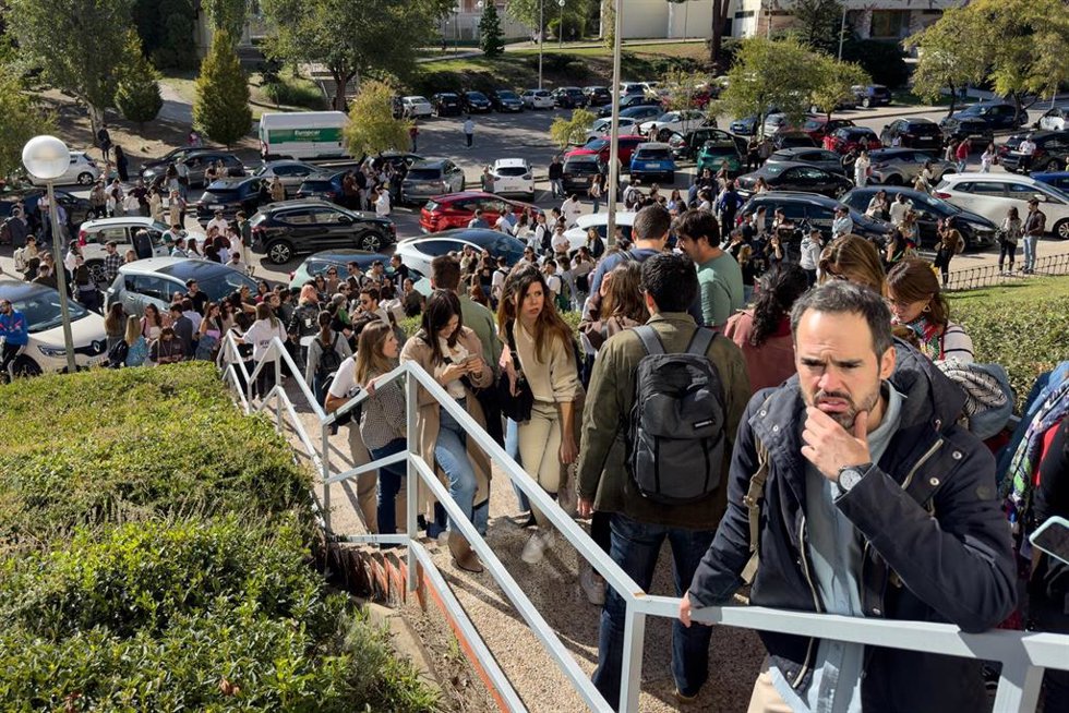 Opositores conversan con un examinador a la entrada del campus de Somosaguas tras el anuncio de la suspensión de los exámenes de oposición de RTVE en Somosaguas