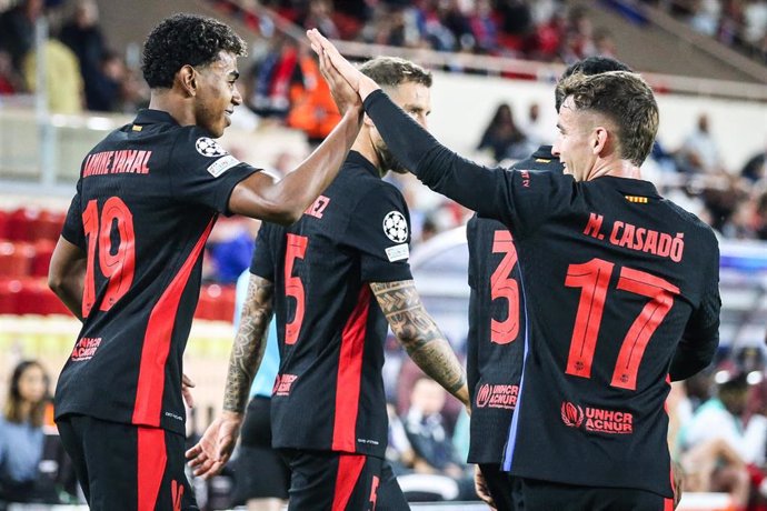 Barcelona's Lamine Yamal (L) celebrates scoring his side's first goal with teammate Marc Casado during the UEFA Champions League soccer match between AS Monaco and FC Barcelona at Louis II Stadium.