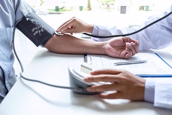 Archivo - Doctor using stethoscope checking measuring arterial blood pressure on arm to a patient in the hospital.