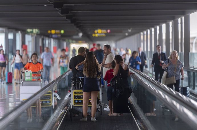 Archivo - Varias personas con maletas en la terminal T4 del aeropuerto Adolfo Suárez Madrid-Barajas.